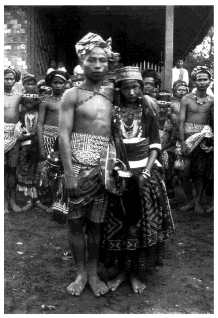 Kain Sarita sering dipakai oleh laki-laki dan perempuan sebagai pakaian pesta. Kulawi. sekitar 1920. Foto oleh Rosenlund